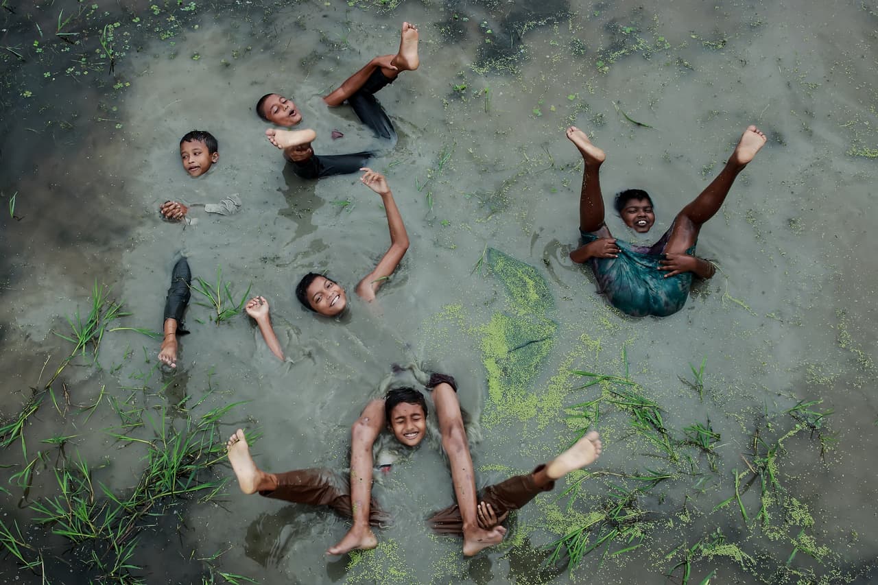 <b>‘Alegría de la infancia’</b>
<br>
<br>Esta imagen resultó finalista del premio. “Cada año, alrededor de nueve pies de lluvia caen en Chittagong, Bangladesh, un poco más de cuatro veces la cantidad que cae en Londres” explicó el premio. 
<br>
<br>“Con el cambio climático, se prevé que las precipitaciones en las regiones monzónicas asiático-australianas aumenten. A medida que el agua de las inundaciones se convierte en la norma, los niños del pueblo celebran y se divierten”, añadió.
<br>