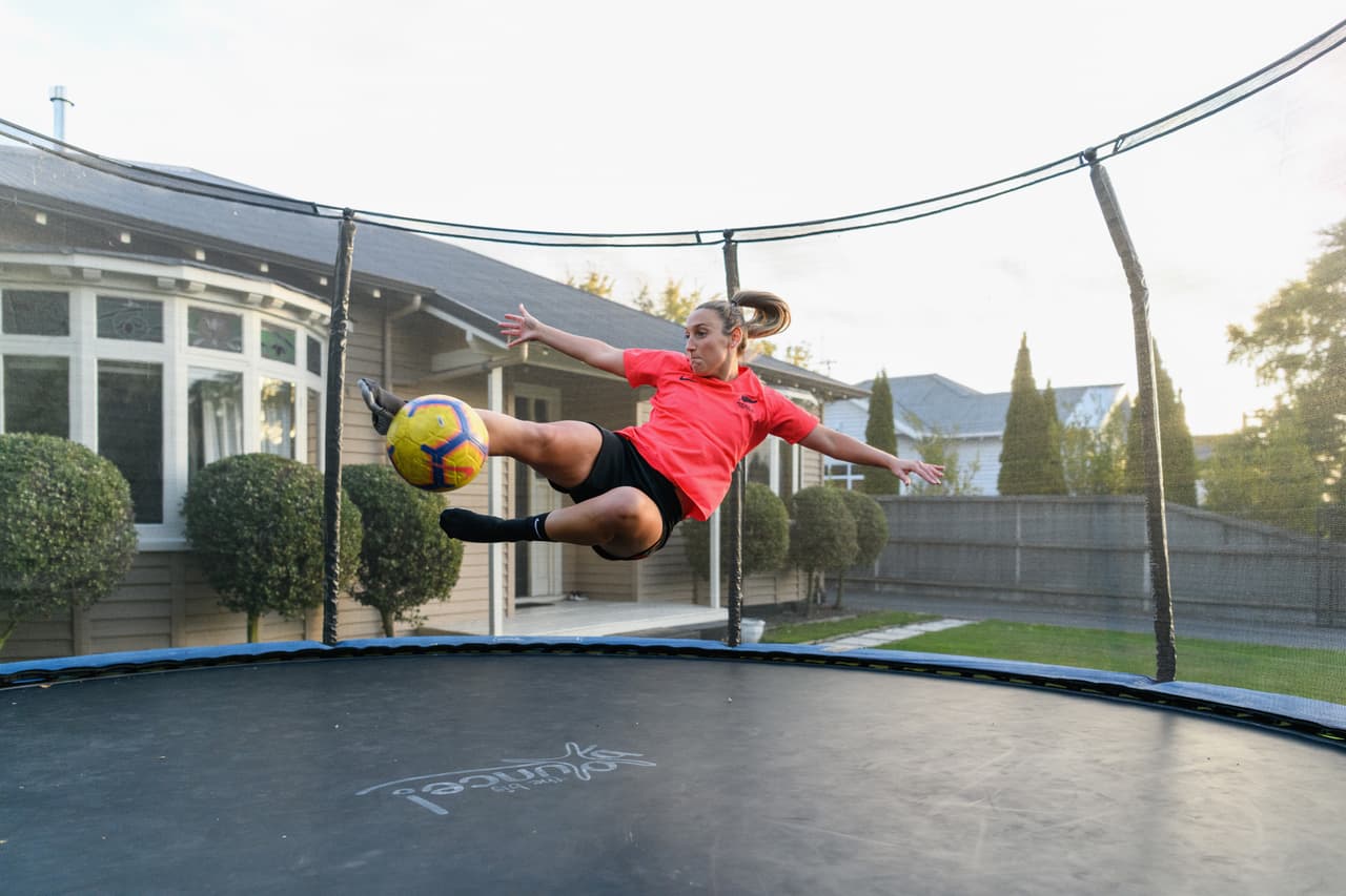 Annalie Longo, jugadora profesional de futbol, usa un trampolín para entrenar en el patio de su casa en Christchurch, Nueva Zelanda. 8 de abril. Algunas ligas profesionales comienzan a planificar aperturas en condiciones especiales, como partidos sin público.