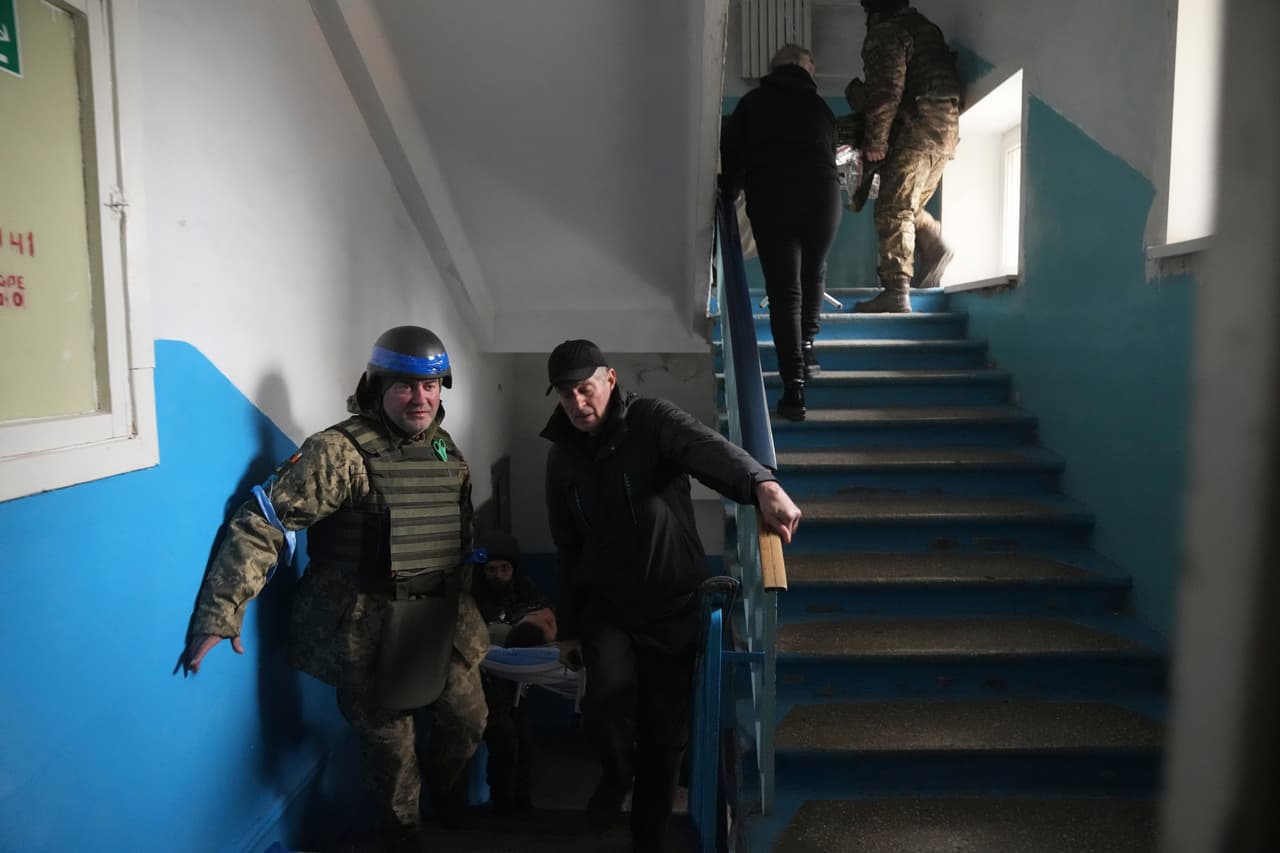 Un militar ucraniano y un civil cargan a un hombre herido por bombardeos en un hospital en Mariupol. 
<br>
<br>El Comité Internacional de la Cruz Roja (CICR) dijo este sábado que las escenas en Mariupol son "desgarradoras" . 
<br>