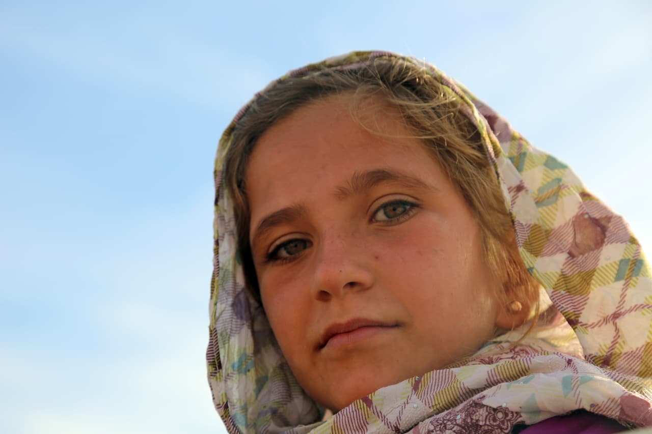 Una niña desplazada en camino hacia Ain Issa, escapa de la violencia en el pueblo de Al-Hisha, en la zona rural de Raqqa, Siria. Algunos de los desplazados llevaban colchones y mantas, otros viajan con su ganado. Ain Issa es el principal punto de parada de las familias desplazadas, a unos 31 millas al norte de la ciudad de Raqqa. 9 de noviembre de 2016.
