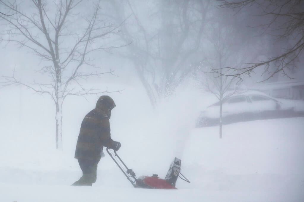 Una persona limpia la nieve mientras una tormenta de invierno atraviesa el oeste de Nueva York el sábado 24 de diciembre de 2022, en Amherst, Nueva York.