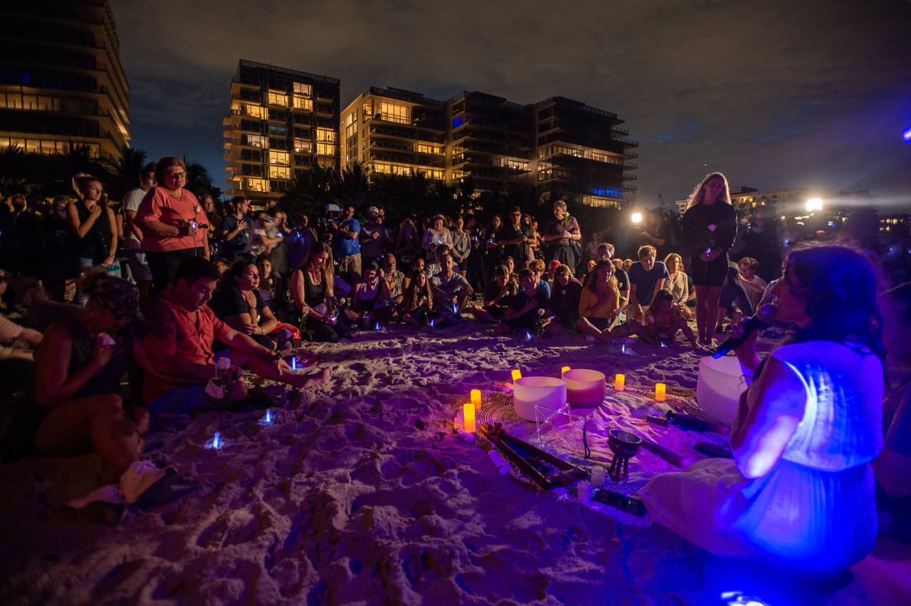 Al cumplirse el quinto día del 
<a href="https://www.univision.com/local/miami-wltv/un-edificio-de-apartamentos-colapsa-en-miami-beach-varias-personas-quedan-atrapadas">derrumbe del edificio de condominios Champlain Towers South,</a> en Surfside, 
<a href="https://www.univision.com/temas/florida">Florida</a>, decenas de personas se congregaron en una vigilia comunitaria en la playa por los desaparecidos.