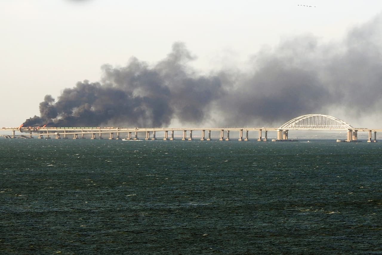 Humo negro sale de un incendio en el puente que une Crimea con Rusia. 
<b>Moscú dijo que un camión bomba provocó que vagones de ferrocarril que transportaban combustible se incendiaran, lo que resultó en un "colapso parcial de dos secciones del puente". </b>
<br>
<br>El puente de 12 millas (19 kilómetros ) cruza el estrecho de Kerch 
<b>que une el Mar Negro y el Mar de Azov se inauguró en 2018 y es el más largo de Europa.</b> 
<br>
<br>