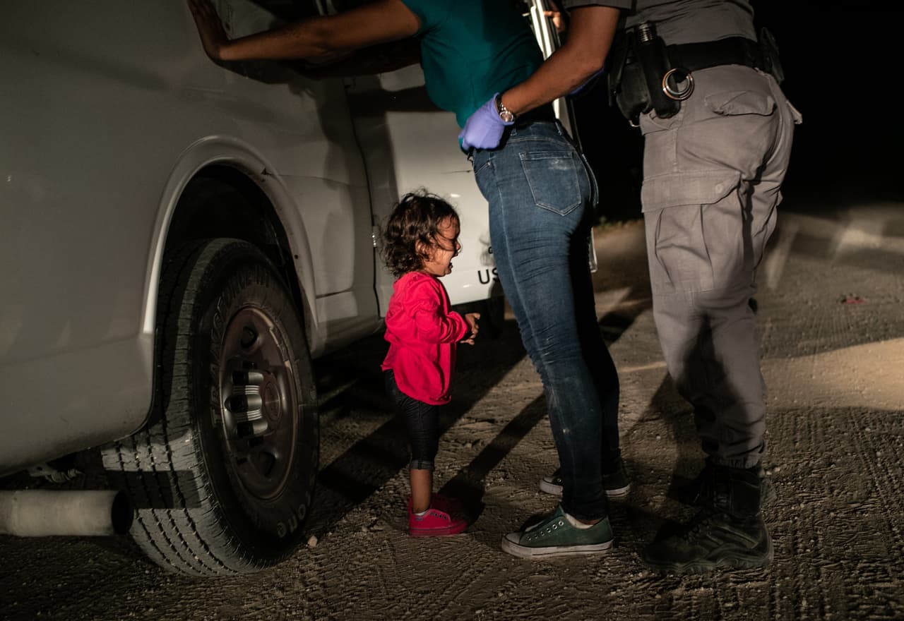Yana, una niña migrante de Honduras llora cuando su madre, Sandra Sanchez, es arrestada por un agente de la Patrulla Fronteriza de EEUU en McAllen, Texas, el 12 de junio de 2018. Miles de familias habían viajado desde distintos países centroamericanos hasta la frontera de México con EEUU y al cruzar fueron detenidas por las autoridades. 
<a href="https://www.univision.com/noticias/inmigracion/la-nina-que-llora-mientras-arrestan-a-su-madre-habla-el-fotografo-que-capturo-la-dura-imagen-fotos-fotos">El gobierno estadounidense había anunciado una política de ‘tolerancia cero’ a la inmigración donde advertían que los migrantes sin documentos serían procesados penalmente.</a> Poco después los medios comenzaron a informar que los padres que habían sido detenidos estaban siendo separados de sus hijos. Esta imagen está nominada a fotografía del año y también en la categoría de Noticias.