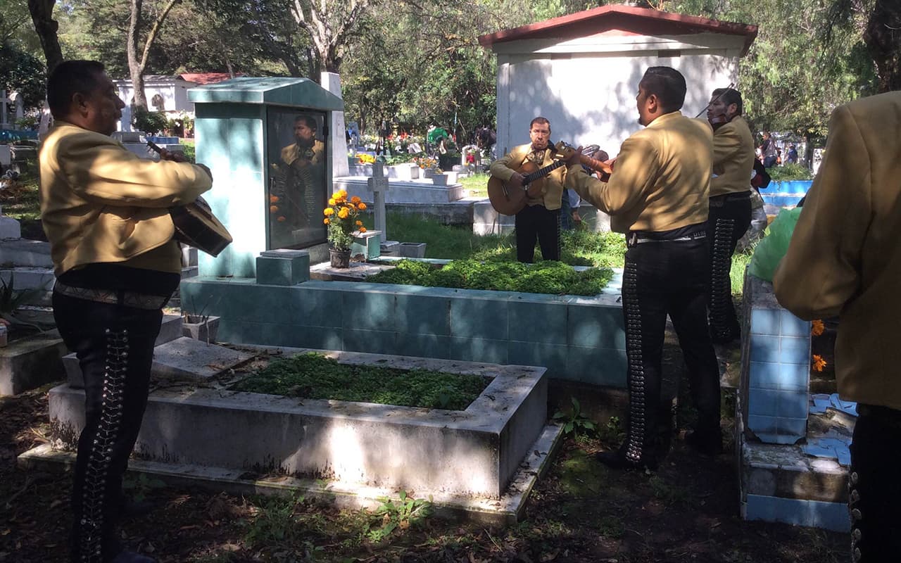 Agrupaciones de mariachis se desplazan por las calles del panteón y cobran entre 5.25 y 7.80 dólares (100 y 150 pesos) por pieza cantada a los difuntos