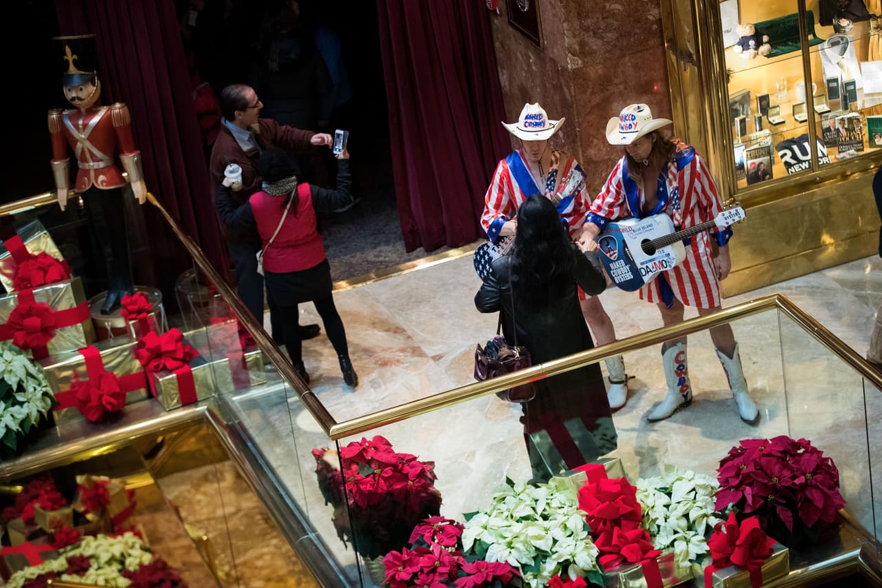Unos músicos vestidos como vaqueros con banderas hablan con las personas dentro del lobby de la torre. 
<br>