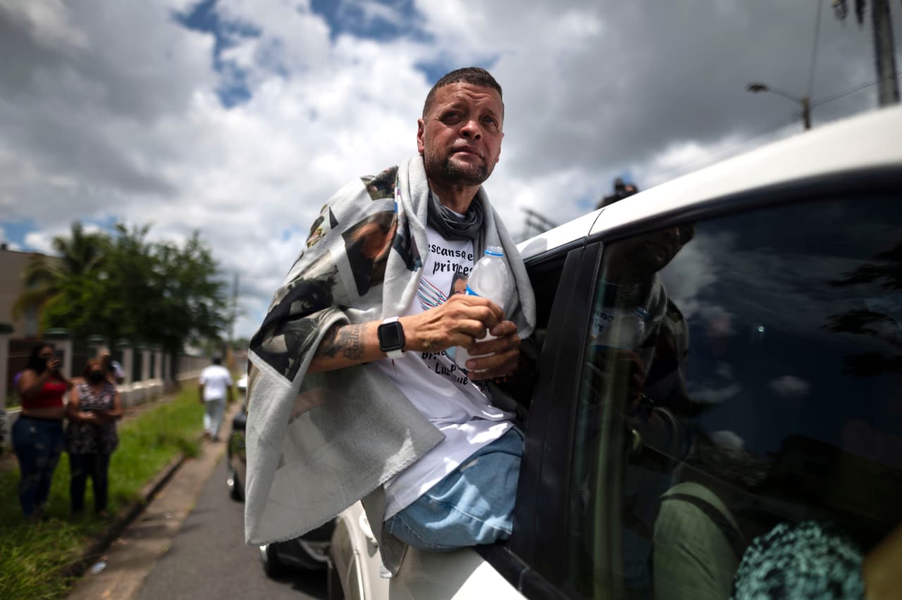 José Antonio Rodríguez se asoma por la ventanilla del automóvil mientras participa en una procesión fúnebre hacia el cementerio de Guaynabo para enterrar a su hija Keishla Rodríguez.
