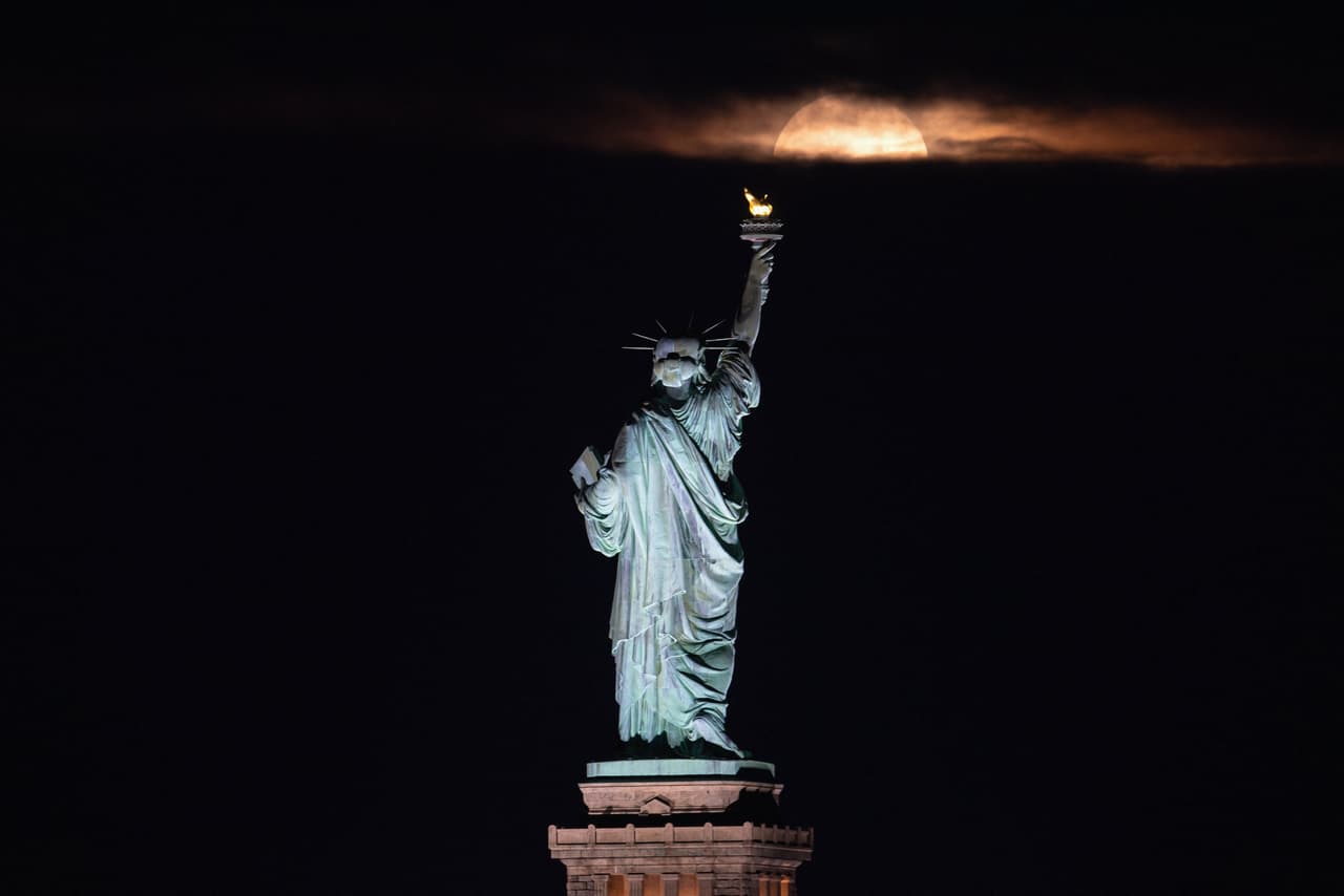 La primera luna llena del verano de 2021 se vio la noche de este jueves. La también llamada “
<i>Strawberry Moon</i>” (“Luna de Fresa”) es la última “
<a href="https://www.univision.com/temas/superluna">superluna</a>” de este año. En esta imagen asoma delante de la Estatua de la Libertad, en 
<a href="https://www.univision.com/temas/nueva-york">Nueva York</a>.