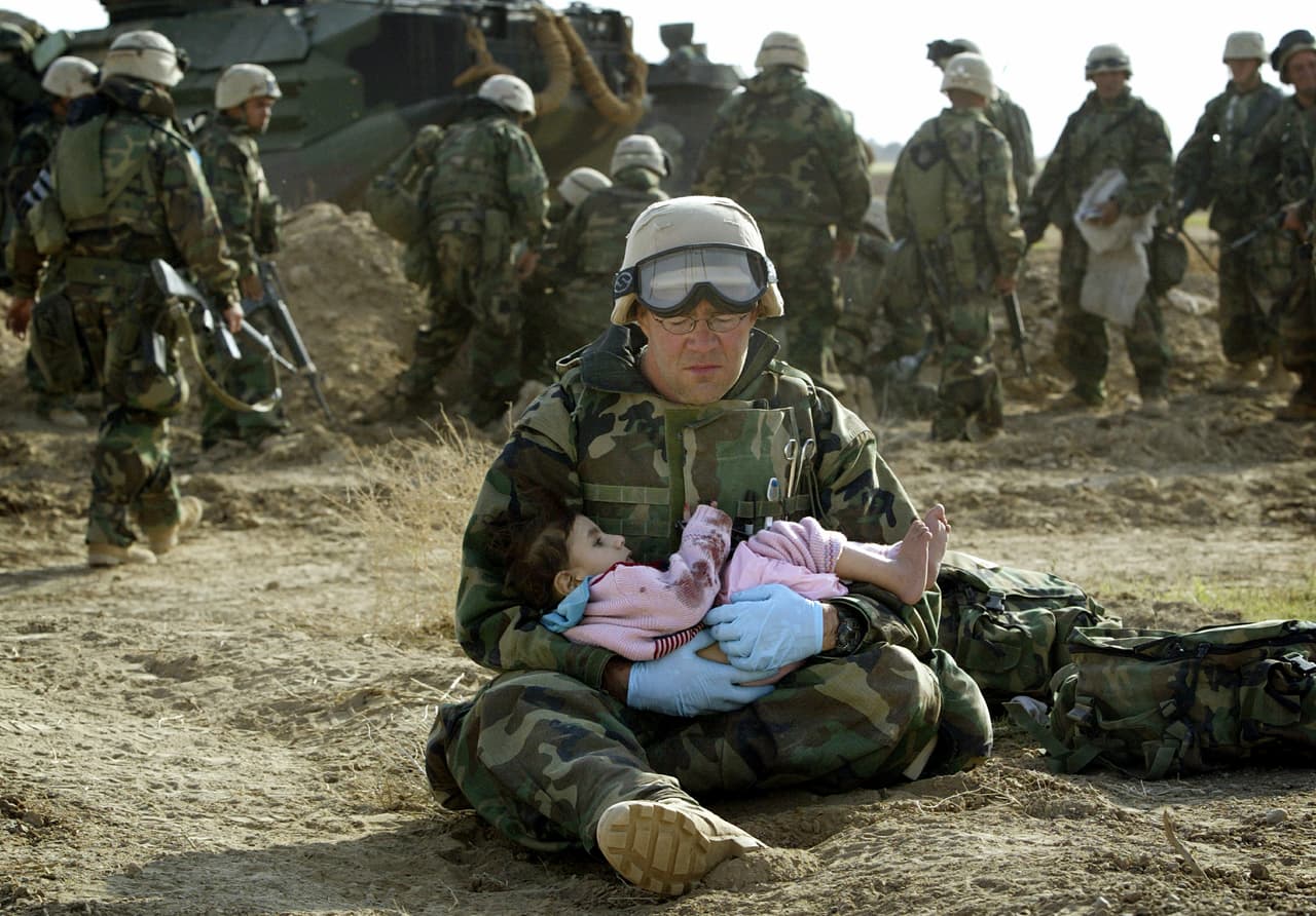 Un estadounidense asiste a un niño herido en un fuego cruzado. EEUU salió definitivamente de Irak en 2011, dejando un país inestable y con diferentes grupos étnicos enfrentados.