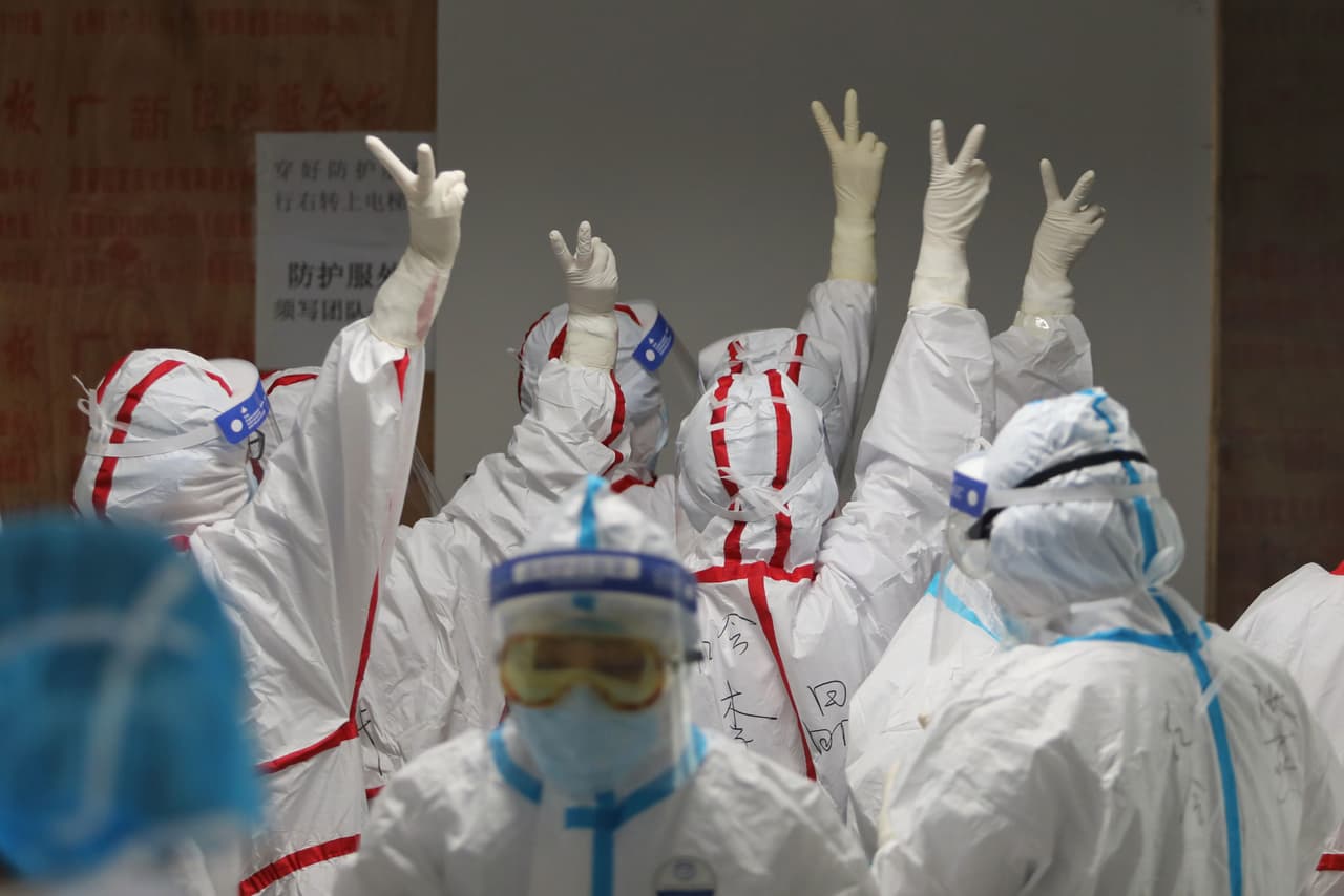 <b>Medicos celebran y</b> 
<b>China asegura que se está recuperando (16 de marzo). </b>El personal del hospital de la Cruz Roja de Wuhan se da ánimo en la sala de cuidados intensivos. El 19 de marzo las autoridades anunciaron que no había reportes de nuevas infecciones locales y que los pocos nuevos casos eran de personas que llegaban al país contagiadas del extrangero.