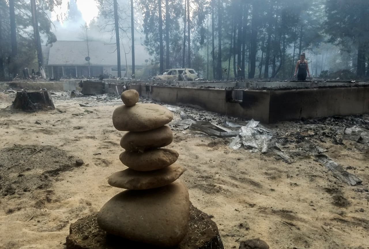 Una mujer camina cerca de los cimientos de una casa quemada tras el paso del incendio McKenzie Bridge, Oregon. Cientos de personas perdieron sus hogares y debieron ser trasladadas de urgencia a refugios.