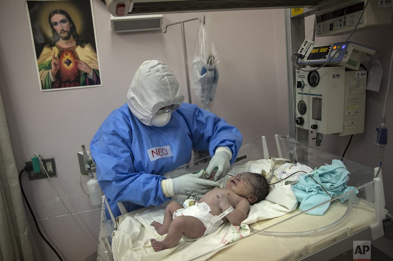 Un neonatólogo examina a un bebé recién nacido en el Instituto Nacional Materno Perinatal
<b> en un área aislada reservada para madres infectadas.</b>
<br>