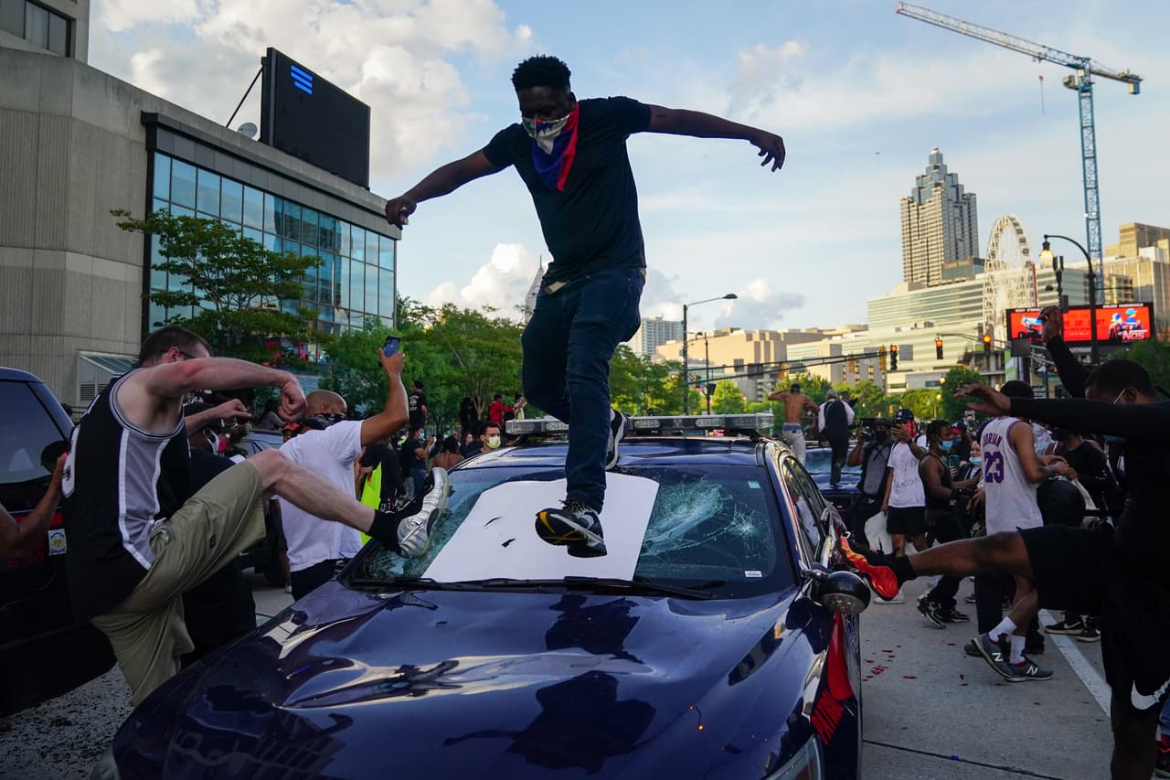 Los manifestantes chocan una patrulla de la policía durante una protesta el 29 de mayo de 2020 en Atlanta, Georgia.