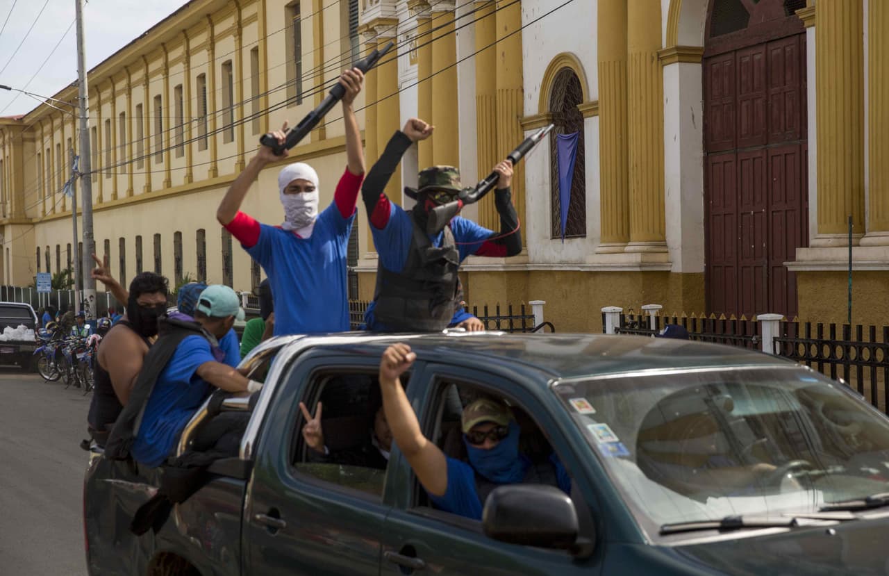 Desde primera hora de la mañana del pasado martes, la ciudad de Masaya, aledaña a Managua, se convirtió en escenario de una operación combinada de policías y paramilitares para desarticular las barricadas de los ciudadanos que se rebelan a Daniel Ortega. En la imagen, un grupo de paramilitares muestran sus armas victoriosos delante de la iglesia de San Sebastián de Masaya, donde hasta la toma de la ciudad, había un memorial a las víctimas de la represión en ese municipio que fue tumbado por estos hombres ilegalmente armados afines al gobierno.