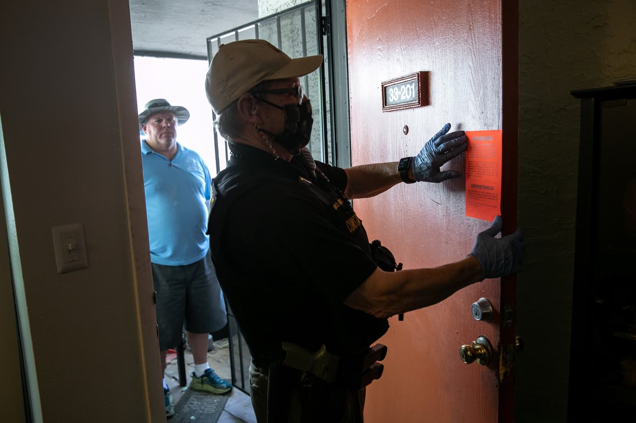 Los 
<a href="https://www.cdc.gov/coronavirus/2019-ncov/downloads/eviction-moratoria-order-faqs.pdf"><u>CDC indican</u></a> que, “los individuos deben buscar la asistencia legal para preguntas relacionadas con la aplicación de la orden de acuerdo a sus circunstancias individuales”. En la fotografía el alguacil del condado de Maricopa, Lenny McCloskey, mientras coloca una orden de desalojo en la puerta de un apartamento en Glendale, Arizona.
<br>