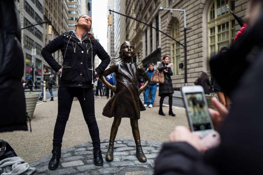 Imitando la pose de la niña, una mujer posa junto a la estatua en 
<b><a href="http://www.univision.com/noticias/trending/8-de-marzo-de-2017-el-dia-internacional-de-la-mujer-se-convierte-en-el-dia-sin-mujeres">el Día Internacional de la Mujer</a></b>. (Getty Images)