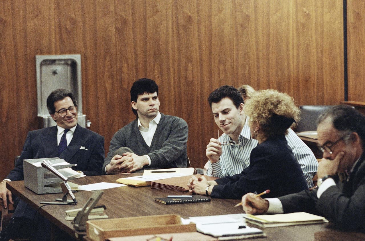 ARCHIVO - Erik Menéndez, en el centro, escucha a su abogado Leslie Abramson, mientras su hermano Lyle observa en Beverly Hills, California, el 17 de mayo de 1991. (Foto AP/Julie Markes, Archivo)