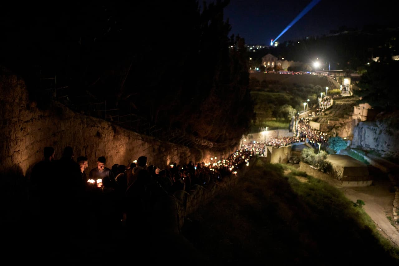 Fieles católicos sostienen velas mientras en una procesión por un camino 
<b>que se cree fue recorrido cuando Jesús fue arrestado y llevado a juicio, </b>fuera de la Ciudad Vieja de Jerusalén.
<br>
<br>
<b>En este propósito lo acompaña el Patriarca Ecuménico Bartolomé, líder espiritual de los ortodoxos, quien ha calificado la iniciativa como un “verdadero paso hacia la reconciliación”. </b>La relación entre ambos líderes ha sido cercana, marcada por gestos simbólicos y declaraciones mutuas de respeto y hermandad.