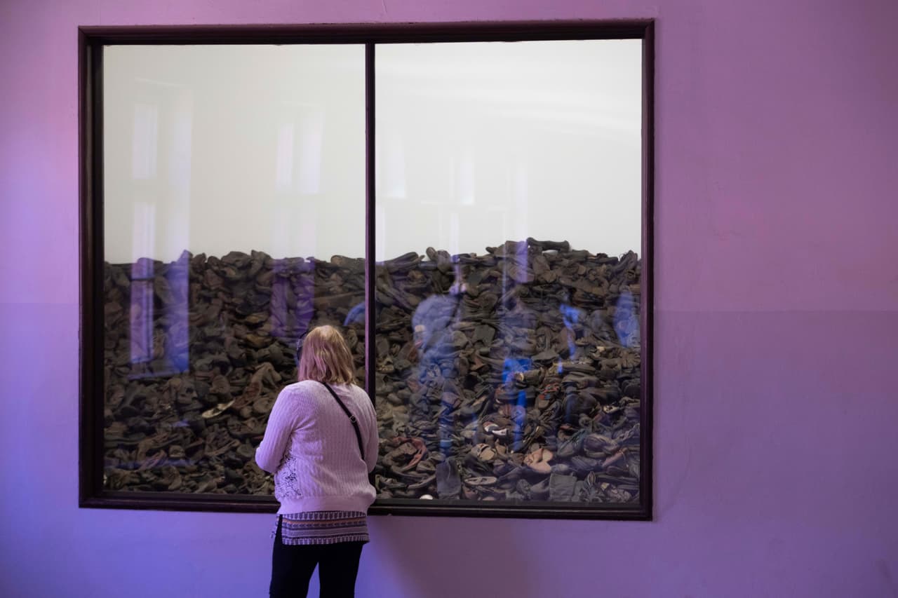 Una mujer observa una exhibición que muestra los zapatos de niños que murieron asesinados en el campo de exterminio de Auschwitz-Birkenau.