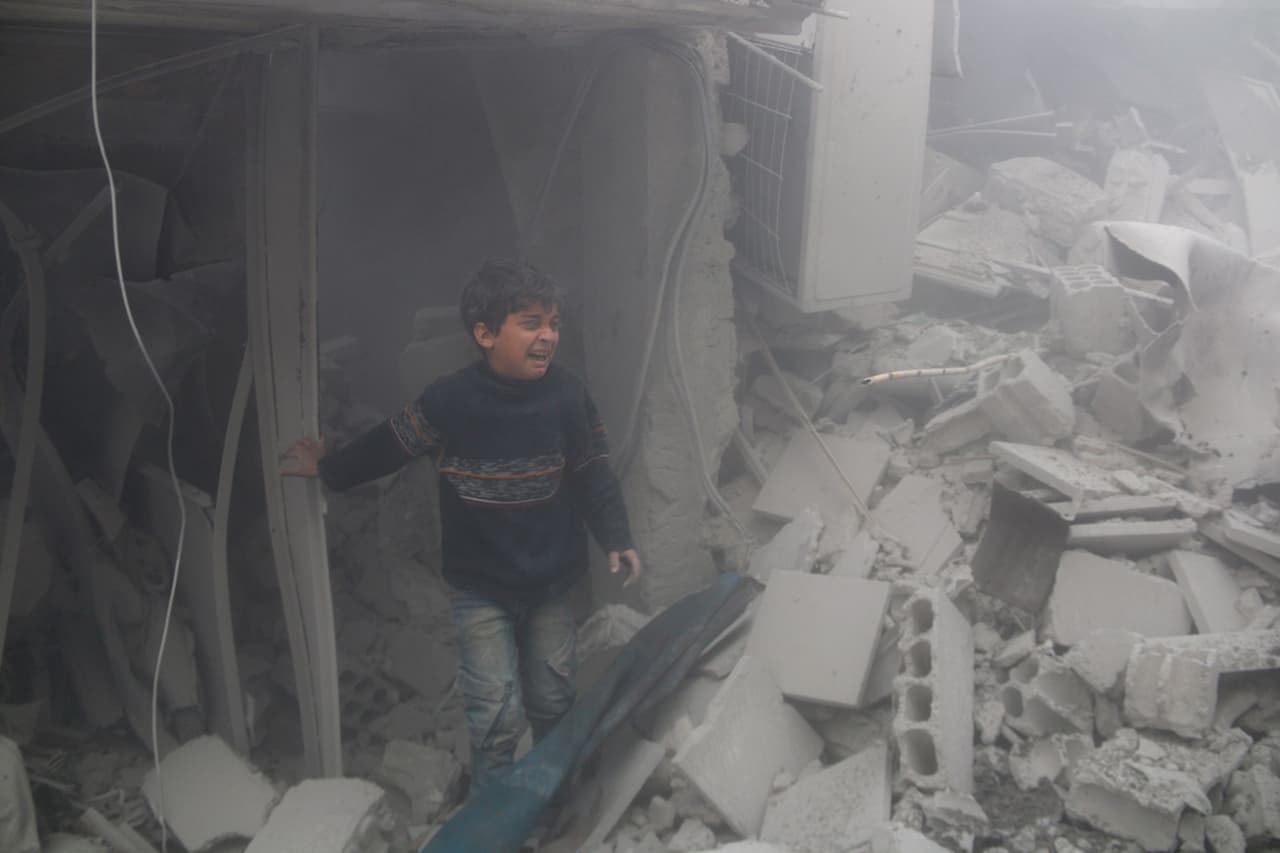 20 de febrero. Un niño llora entre los escombros de los edificios derrumbados tras un bombardeo en la ciudad de Arbin, Guta.