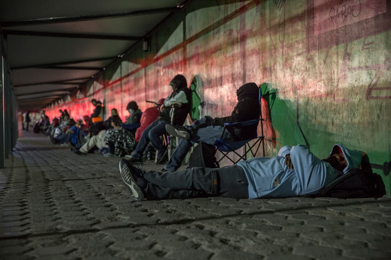 Unos hacen fila de pie y otros duermen mientras esperan la apertura de la frontera. Los puertos de entrada se mantienen cerrados entre las 10 de la noche y las 6 de la mañana.