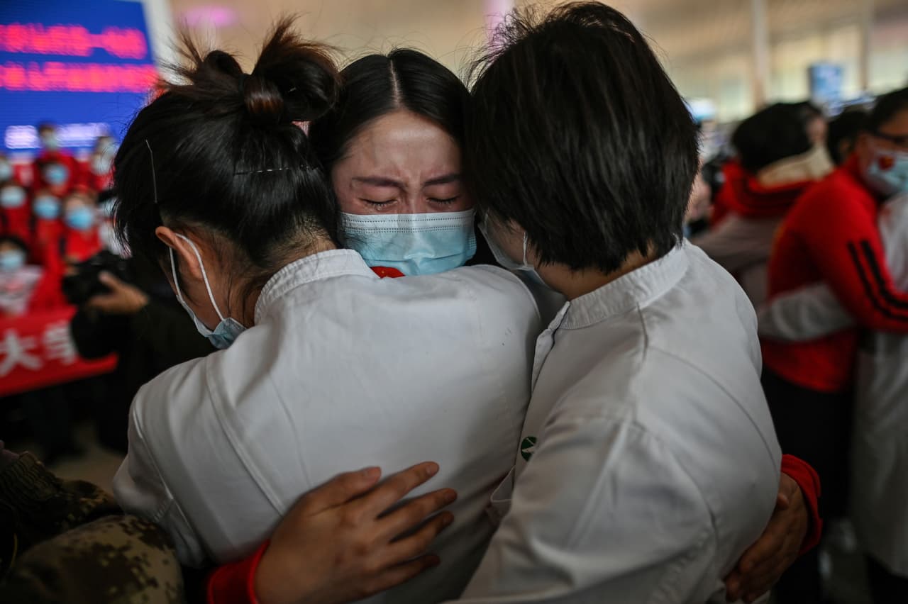 Trabajadores de la salud se abrazan durante la ceremonia de apertura del aeropuerto de Wuhan el ocho de abril, uno de los momentos cumbres de la pandemia en Wuhan registrados por Retamal. El aeropuerto se había mantenido cerrado desde enero y para algunos médicos de otras provincias esta era la primera oportunidad de regresar a sus casas desde el inicio de la crisis.