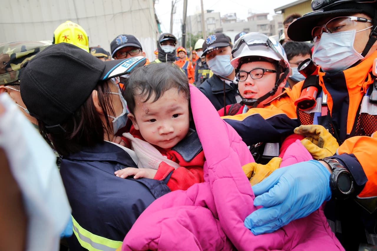 Rescatistas sacan a un niño de entre los escombros de un edificio que se vino abajo tras un sismo en Tainan, Taiwán, el 6 de febrero de 2016. (Foto AP/Wally Santana)