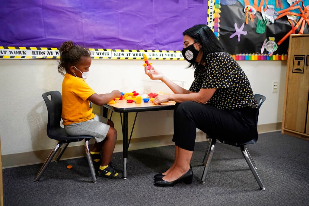 La maestra Juliana Urtubey interactúa con Kamari Wolfe en una clase en la escuela primaria Kermit R Booker.
