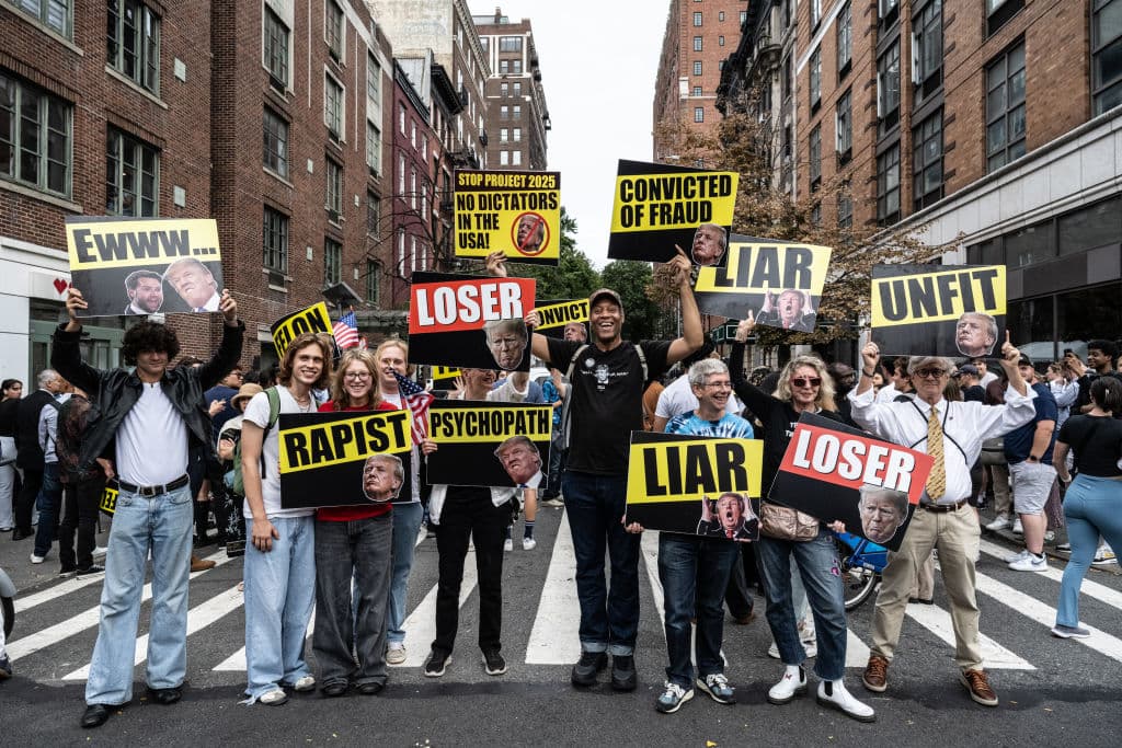 Grupos de derechos civiles apoyaron la protesta con pancartas que resaltan controversias del expresidente.