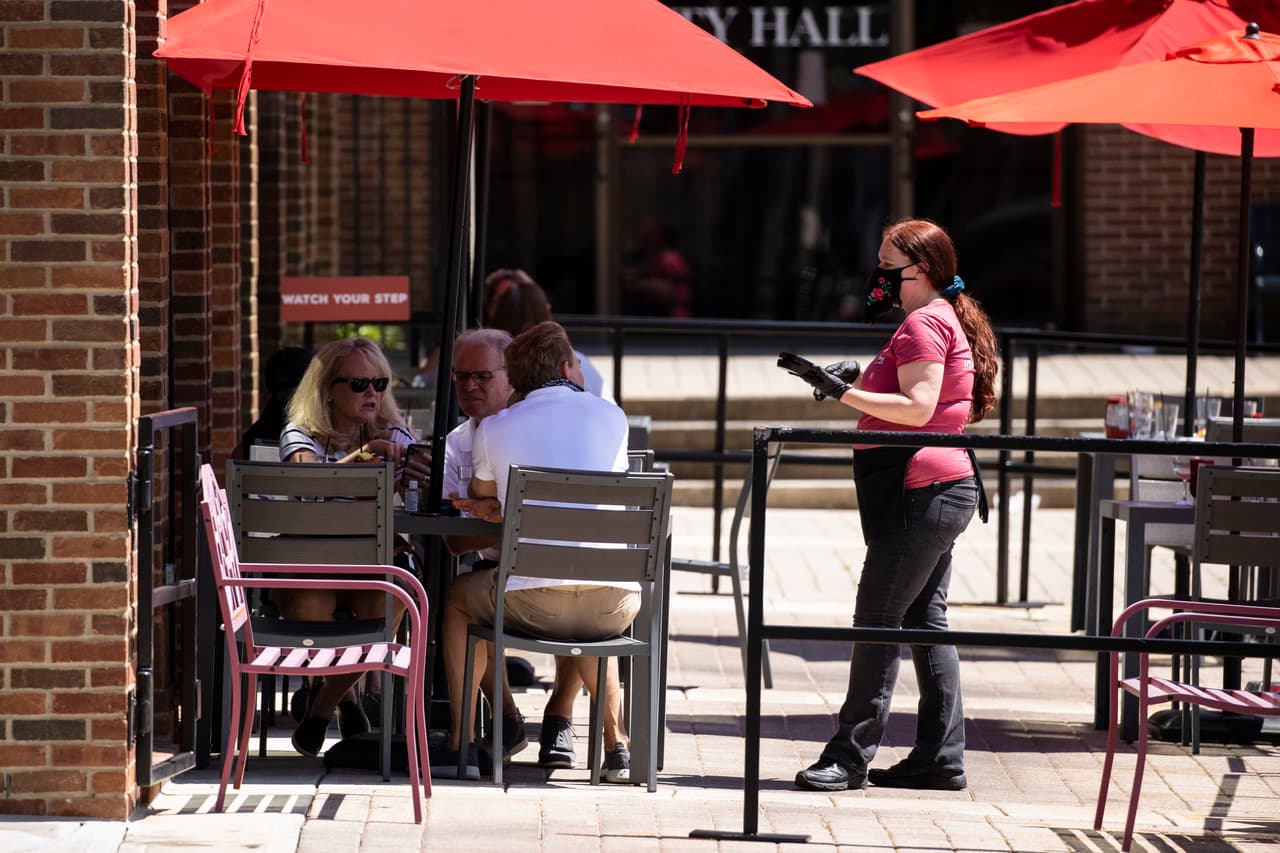 <b>Tennessee. </b>Clientes atendidos en el exterior de un restaurante en la ciudad de Franklin el 2 de mayo, cuando comenzó la reapertura en este estado.
<br>
<br>Desde entonces los casos comenzaron aumentar y en Memphis los bares se cerraron nuevamente a principios de julio y los restaurantes no pueden servir después de las 10 PM. En Nashville se redujo el límite de ocupación de restaurantes, que había estado en un 75%, nuevamente al 50%, y los bares ahora están cerrados.