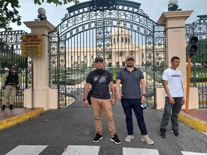 Exsoldados colombianos posan frente a la puerta de entrada al Palacio Nacional en Santo Domingo, camino a Haiti.