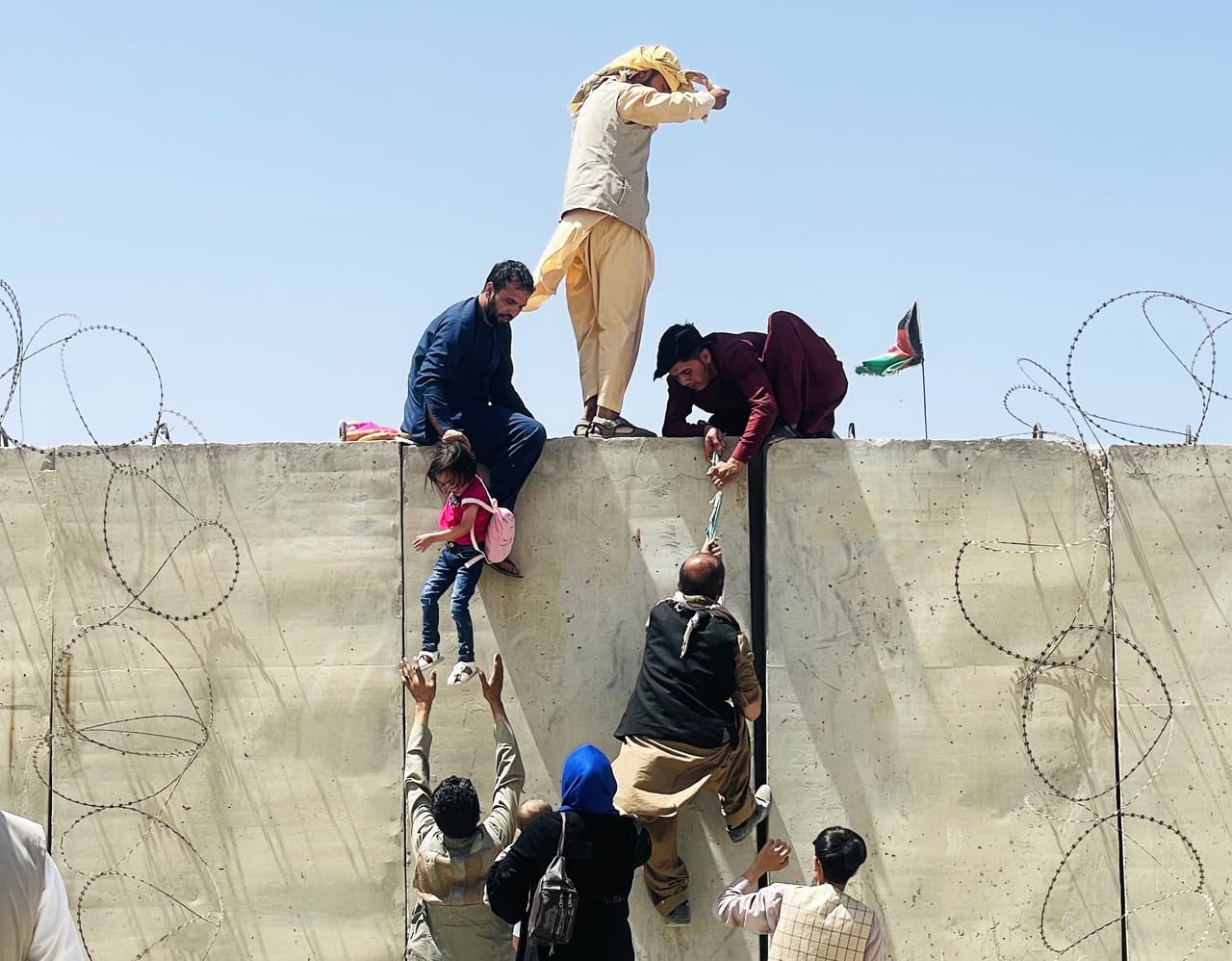 Un grupo de afganos saltó un muro para entrar al aeropuerto, en la mañana del lunes 16 de agosto. La turba dejó decenas de personas golpeadas, entre ellos niños.