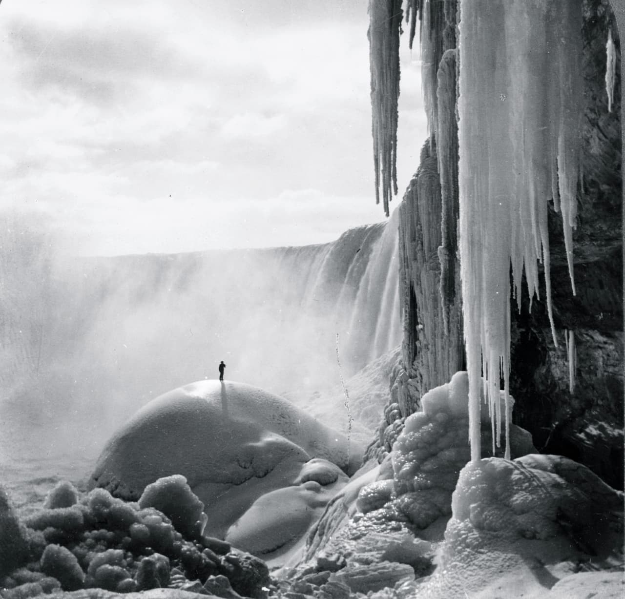 En esta fotografía de 1903 un hombre camina bajo las cascadas congeladas. Entonces el hielo río arriba reducía el volumen de agua hasta congelar las cascadas.
