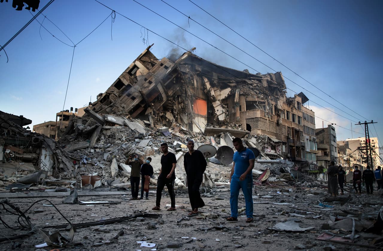 Un grupo de palestinos junto a los restos de un edificio de 15 pisos destruido por los ataques aéreos israelíes en la ciudad de Gaza, el 13 de mayo.