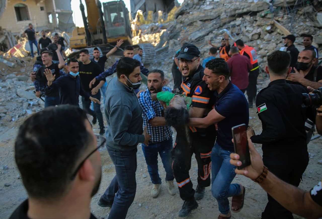 Un grupo de palestinos lleva el cuerpo de un niño que encontraron muerto bajo los escombros en Beit Lahiya, al norte de la Franja de Gaza. El director regional de UNICEF dijo que la mitad de los niños muertos en Gaza tenían menos de 10 años, mientras que decenas de otros niños palestinos resultaron heridos en Cisjordania y Jerusalén Oriental.
<br>
