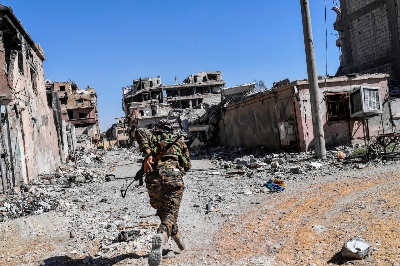 Un soldado del Fuerzas Democráticas Sirias se desplaza por las adyacencias del estadio de Raqqa, en uno de los últimos enfrentamientos contra EI antes de la liberación total de la ciudad.