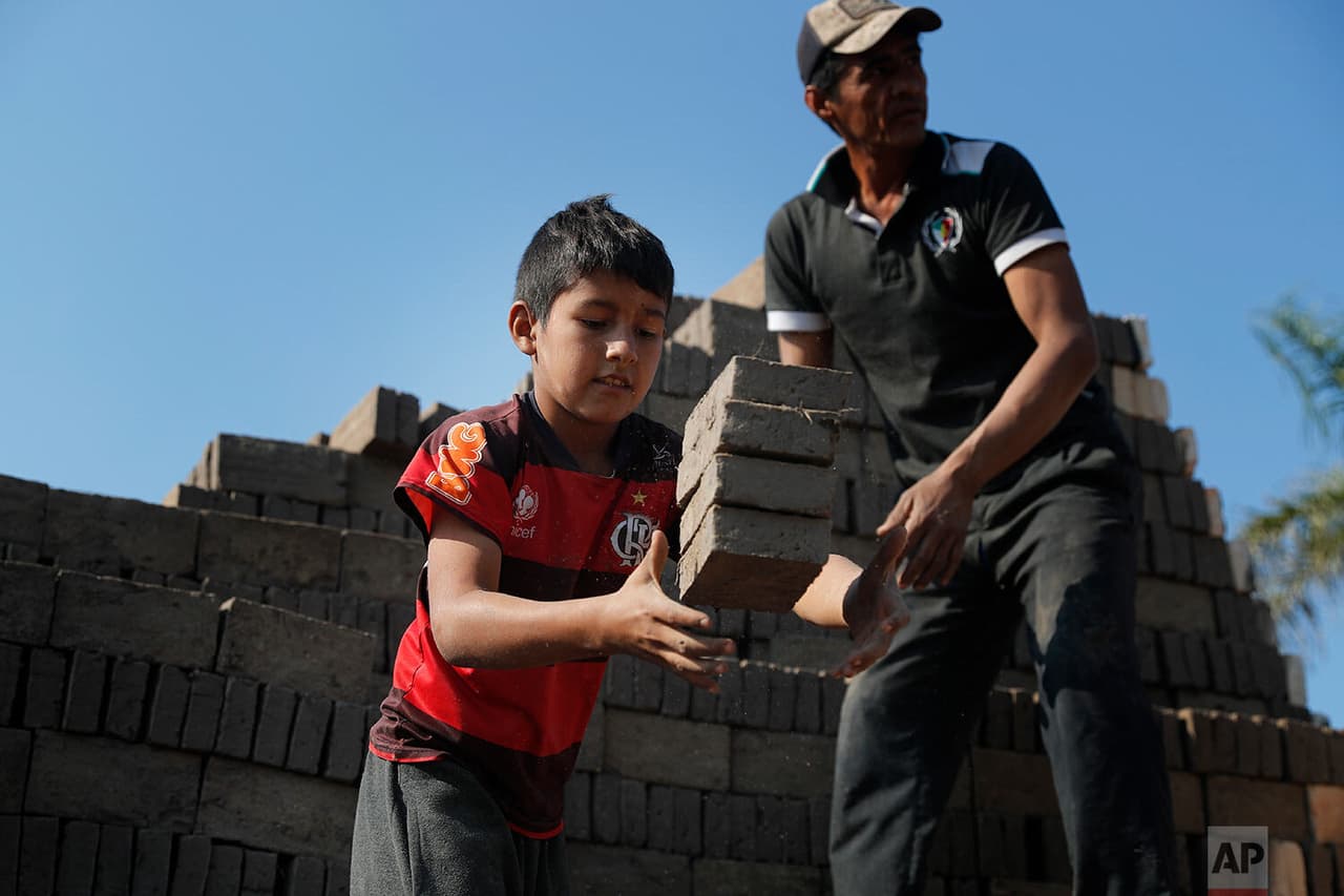 Alejandro, de 9 años,
<b> atrapa ladrillos para entregárselos a un hombre que los mete en el horno en una fábrica de ladrillos dirigida por sus tíos</b>. Miembros de familias de ladrilleros dijeron que, debido al cierre de las escuelas a causa del covid-19, muchos niños y adolescentes se han puesto a trabajar a tiempo completo. 
<br>