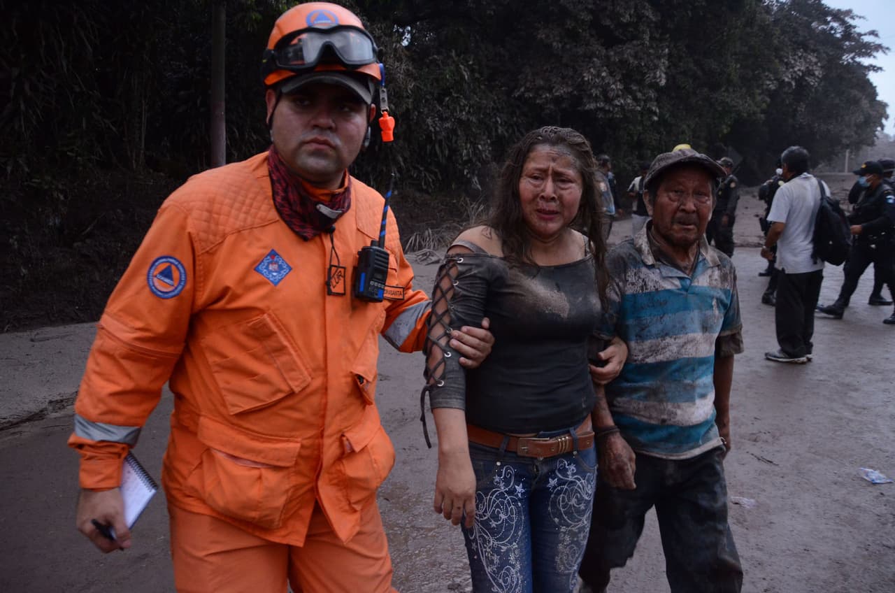 A rescue worker assists survivors of the volcanic eruption.