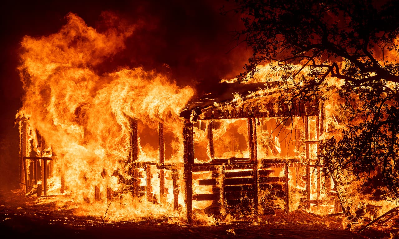 Una estructura se quema cuando el incendio Carr corre a lo largo de la carretera 299 cerca de Redding, California.