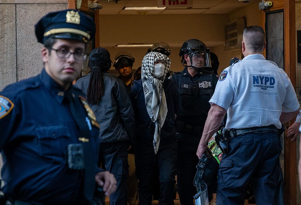 Fuera de la biblioteca, simpatizantes de la causa se congregaron alrededor de las barreras metálicas instaladas por la policía, coreando "Liberen Palestina" mientras observaban la detención de los manifestantes, quienes fueron escoltados con las manos atadas a la espalda.