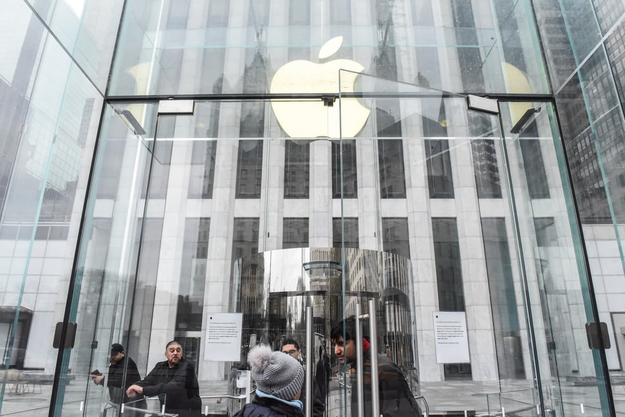 Un empleado de la tienda insignia de Apple en la Quinta Avenida de Nueva York le indica a un cliente en la puerta del local que cerraron para evitar la propagación del coronavirus.