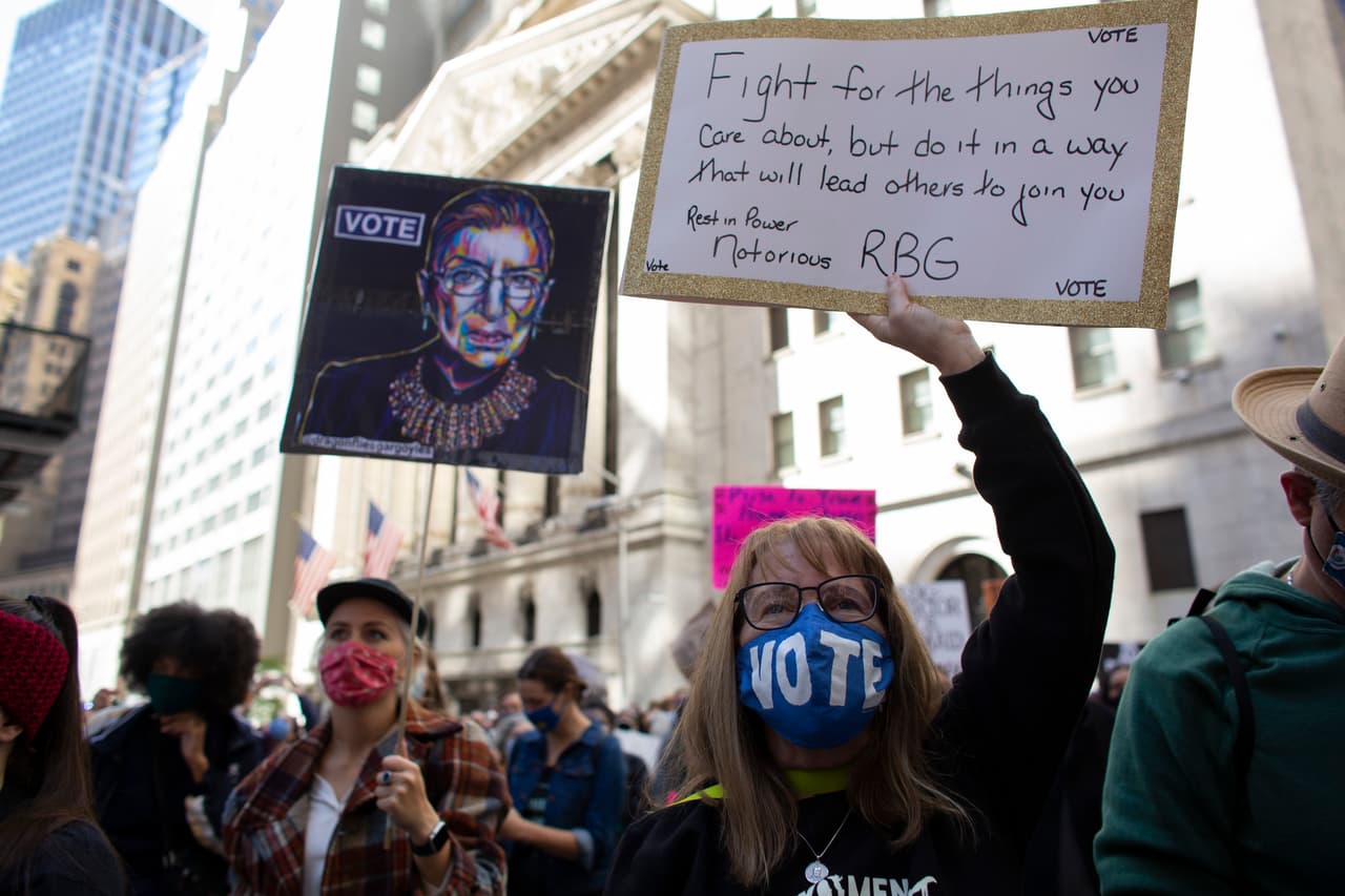 Una de las manifestantes llevaba una mascarilla invitando al voto, mientras portaba una pancarta en la que repetía el mensaje de RBG: "Pelea por las cosas que te importan, pero hazlo de una forma que lleve a los otros a sumarse".