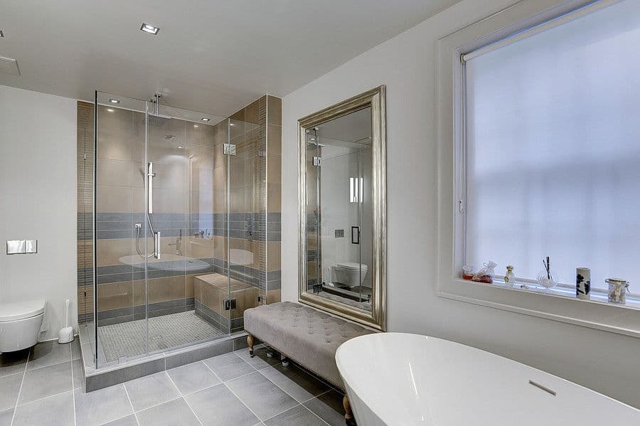 Los cuartos de baño también siguen las líneas depuradas del interiorismo de toda la casa. La bañera exenta y el canapé dan el toque lujoso a un baño de materiales funcionales.