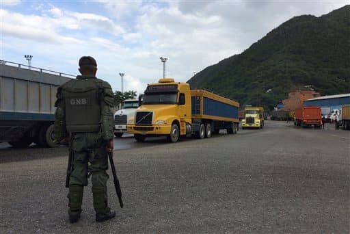 Un soldado de la Guardia Nacional vigila camiones que salen del puerto en Puerto Cabello, el pasado 19 de diciembre. En toda la cadena de mando, de los generales de alto nivel a los soldados de a pie, los militares utilizan su creciente poder sobre el suministro de comida para lucrarse, denuncia 'The Associated Press'.