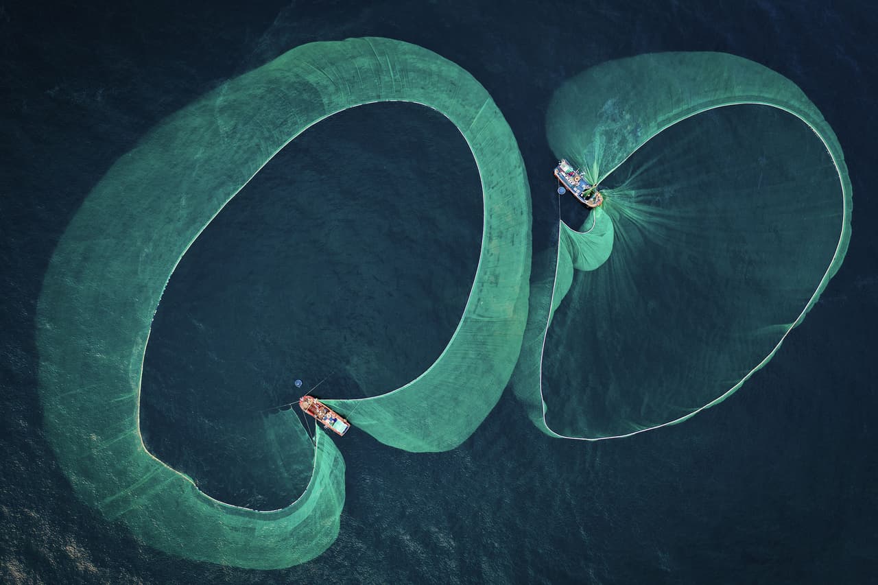 <b>‘Temporada de pesca de anchoas’</b>
<br>
<br>El autor de esta foto fue el ganador en la categoría ‘salvemos nuestros mares’ y es el Fotógrafo de Conservación marina del Año 2022.
<br>
<br>La foto muestra dos barcos buscando anchoas en la provincia de Phu Yen, en Vietnam. “La anchoa salada es la materia prima más importante en la salsa de pescado vietnamita tradicional”, dijo el autor de la foto. “Las reservas de esta materia prima han disminuido un entre 20 y 30% en los últimos 10 años”, agregó.
<br>