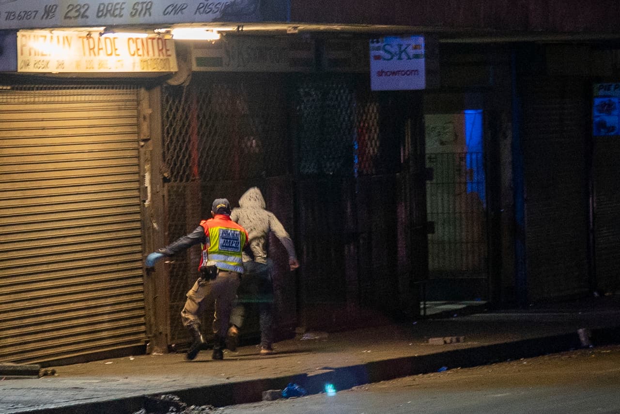 <b>Perseguido por violar la cuarentena (27 de marzo). </b>Un oficial de policía persigue a un hombre que violó el cierre del centro de Johannesburgo, Sudáfrica. África subsahariana registró su primera infección a finales de febrero en Nigeria, la nación más poblada de ese continente. El paciente era un ciudadano italiano que había regresado a Lagos desde Milán.