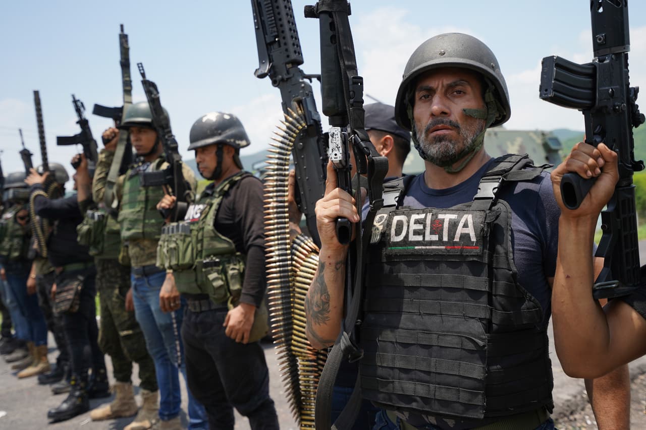 Presuntos sicarios del Cartel de Jalisco sujetan rifles de guerra en el municipio de Aguililla, a 270 kilómetros al suroeste de Morelia, la capital de Michoacán. El poblado fue tomado por esta organización criminal, de acuerdo con la agencia que tomó la imagen, Cuartoscuro.