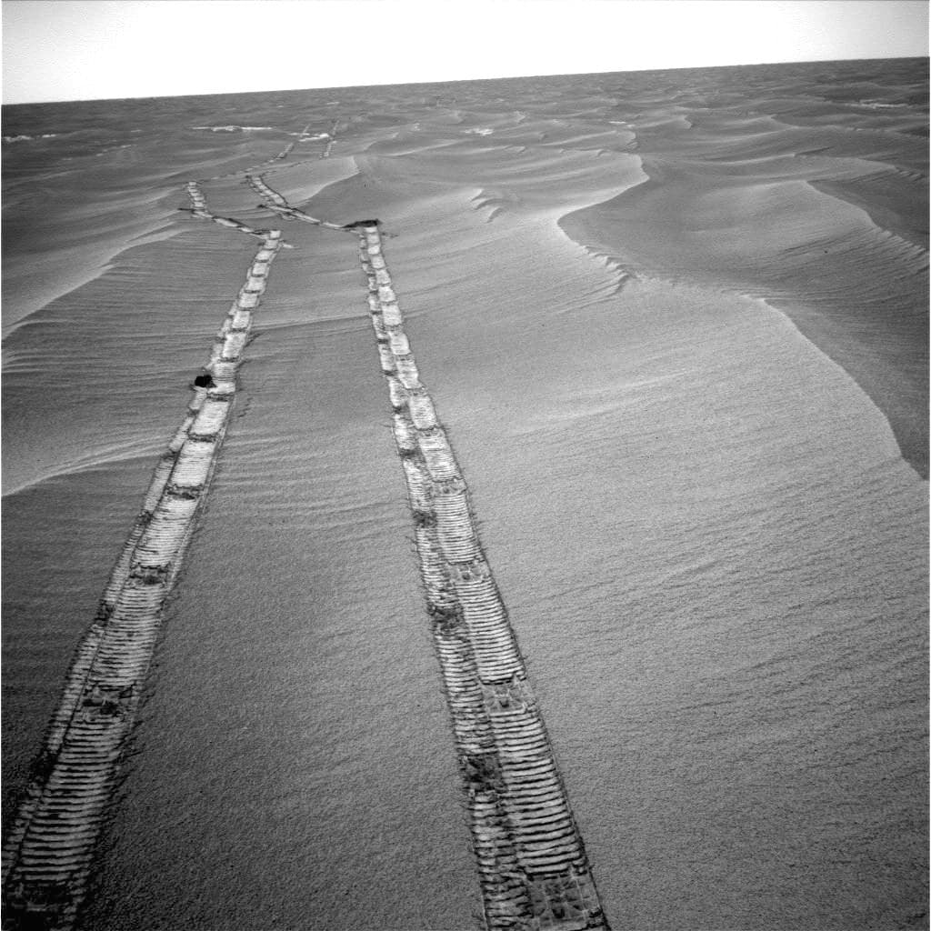 El rover Opportunity capturó esta imagen de las huellas que dejó cuando buscaba una posición favorable para mejorar la recepción de los rayos solares esenciales para su funcionamiento. Este aparato fue lanzado en 2003 y culminó su misión en febrero de 2019.