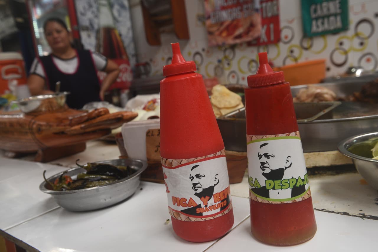 En un local de comida mexicana, en el estado de Tabasco, los despachadores de salsa llevan imágenes AMLO indicando el nivel de picante.