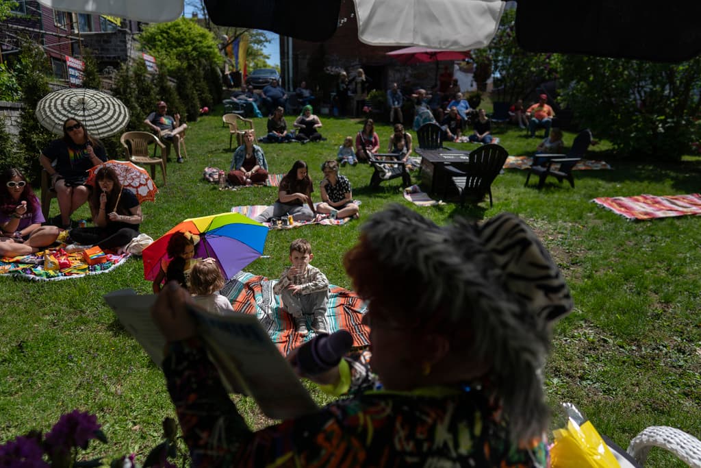 La drag queen Alexus Daniels lee "Coat of Many Colors" de Dolly Parton a niños, familiares y amigos en la actividad "Drag Storytime!" en Mt. Carmel, Pensilvania, en el jardín de Pink Moon Collective.